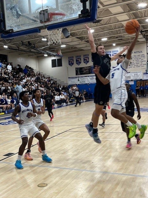 Palm Beach Central's Matthew Puodziukaitis prepares to block a driving layup attempt by Wellington's Jeremy Tovar (5) during the second half Friday night at Wellington High.