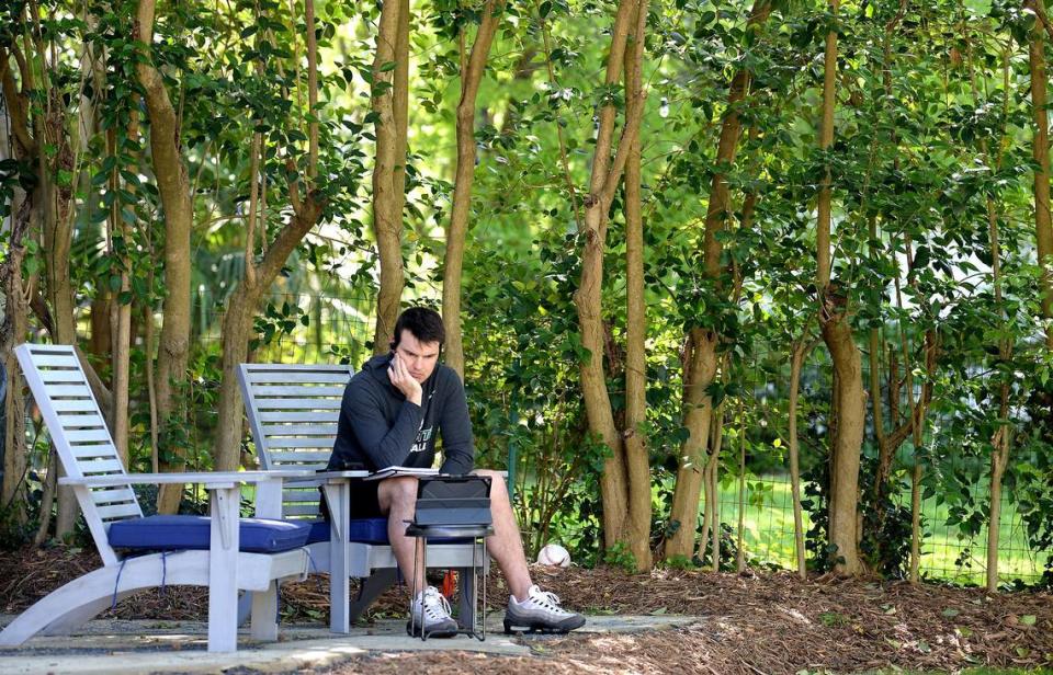 Charlotte 49ers head football coach Will Healy sits in his backyard listening to a conference call with Conference USA on Tuesday, April 14, 2020.