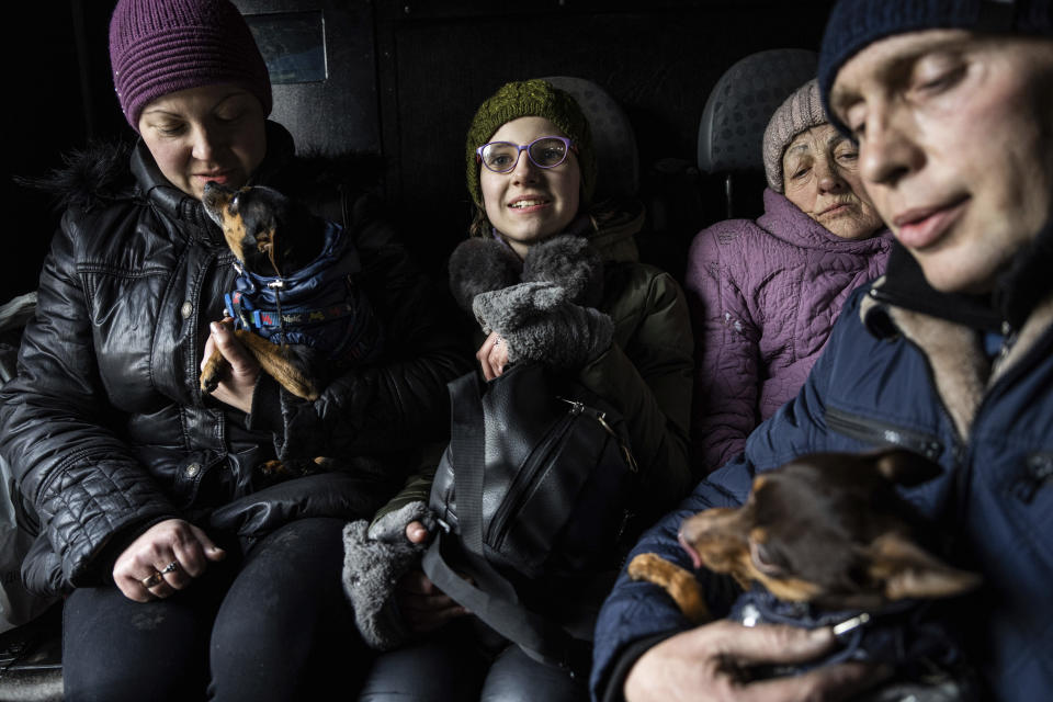 Arina, center, rides inside a car with her family during an evacuation by Ukrainian police, in Avdiivka, Ukraine, Tuesday, March 7, 2023. For months, authorities have been urging civilians in areas near the fighting in eastern Ukraine to evacuate to safer parts of the country. But while many have heeded the call, others -– including families with children -– have steadfastly refused.(AP Photo/Evgeniy Maloletka)