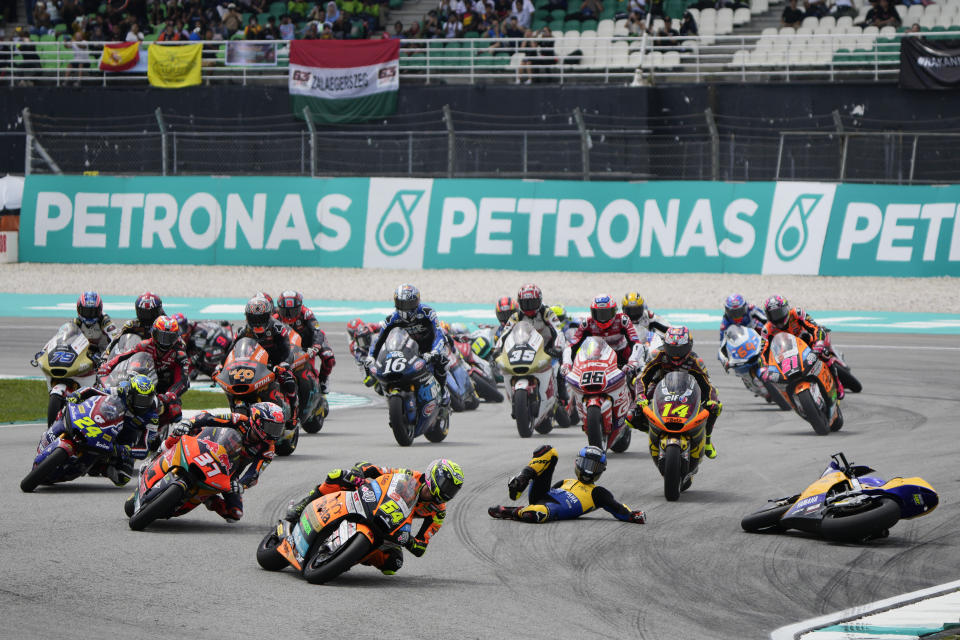 Spain's rider Fermin Aldeguer, foreground, leads as Spains rider Manuel Gonzalez Simon falls during Moto2 class race of the MotoGP Malaysian Grand Prix at the Sepang International Circuit in Sepang, Malaysia Sunday, Nov. 12, 2023. (AP Photo/Vincent Thian)