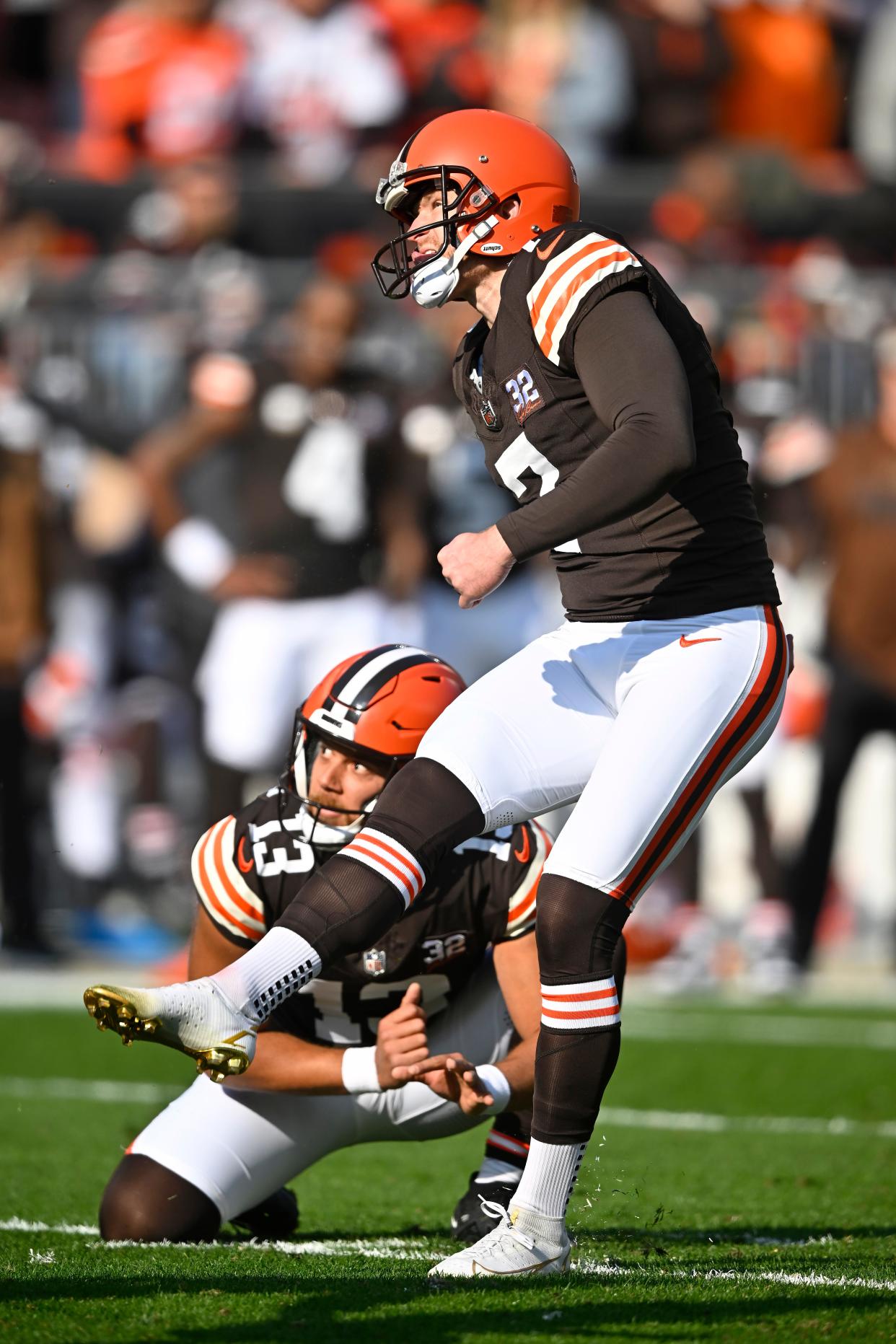 Cleveland Browns place kicker Dustin Hopkins, top, kicks a field goal from the hold of Corey Bojorquez (13) against the Arizona Cardinals on Sunday in Cleveland.