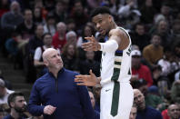 Milwaukee Bucks' Giannis Antetokounmpo points to where he injured his right wrist, while talking to a member of the medical staff as they head to the locker room during the first half of the team's NBA basketball game against the Chicago Bulls on Thursday, Feb. 16, 2023, in Chicago. (AP Photo/Charles Rex Arbogast)