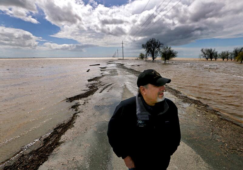 LEMOORE, CALIF. - MAR. 21, 2023. Agribusiness consultant Mark Grewel stands on a farm road that was flooded near Corcoran after recent heavy rains in the vast and fertile San Joaquin Valley. Grewel predicts that the area will experience greater flooding as more snow on local mountains melts with the advent of spring. Tulare Lake, a ghost lake that was drained more than 100 years ago, is now the location of large growing operations. It is filling up after a stormy winter. . (Luis Sinco / Los Angeles Times)