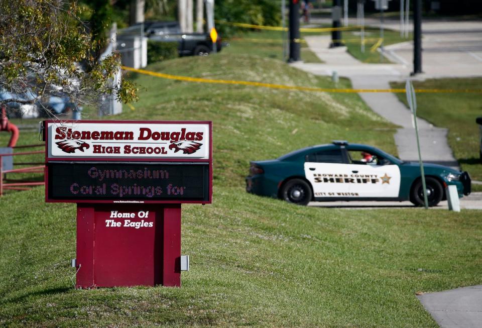 Law enforcement officers block off the entrance to Marjory Stoneman Douglas High School in Parkland on 15 February 2018 (AP)