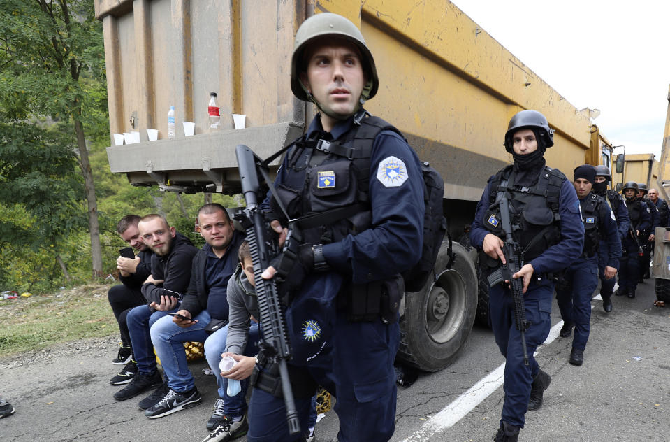 Kosovo police officers patrol by trucks where Kosovo Serbs block a road near the northern Kosovo border crossing of Jarinje, Monday, Sept. 20, 2021. Tensions soared Monday at the border between Kosovo and Serbia as Kosovo deployed additional police to implement a rule to remove Serbian license plates from cars entering Kosovo, while Serbs protested the move. (AP Photo/Bojan Slavkovic)