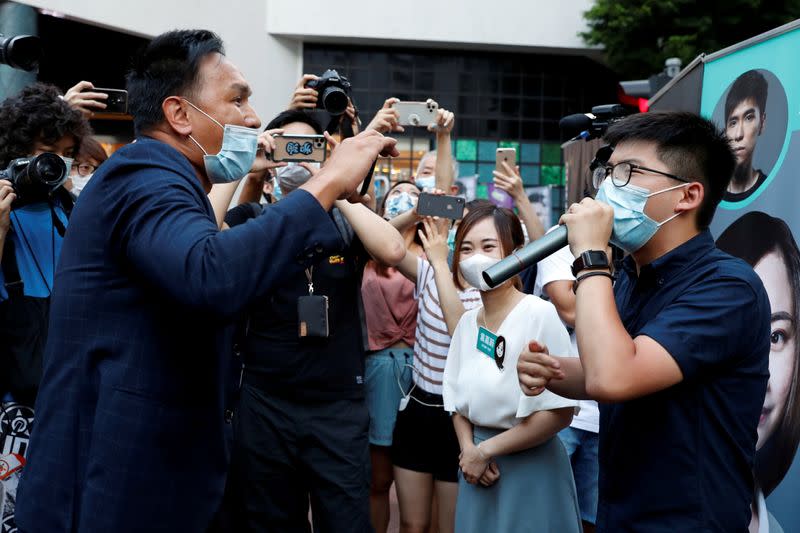 Pro-China activist Man Shek Fong Yau hurls insults at pro-democracy activists Joshua Wong and Tiffany Yuen Ka-wai during primary elections aimed at selecting democracy candidates, in Hong Kong