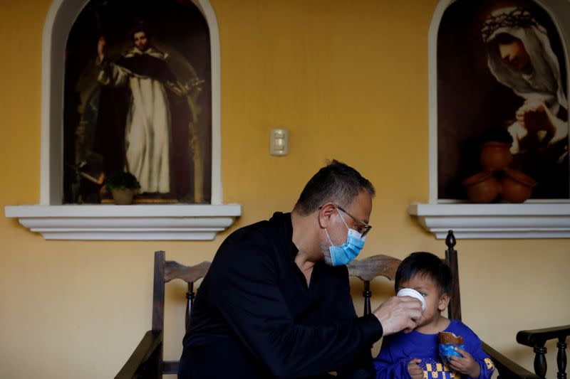 FILE PHOTO: Fray Carlos Caceres gives a beverage to an unaccompanied child who was deported from the U.S., at a shelter in Guatemala City