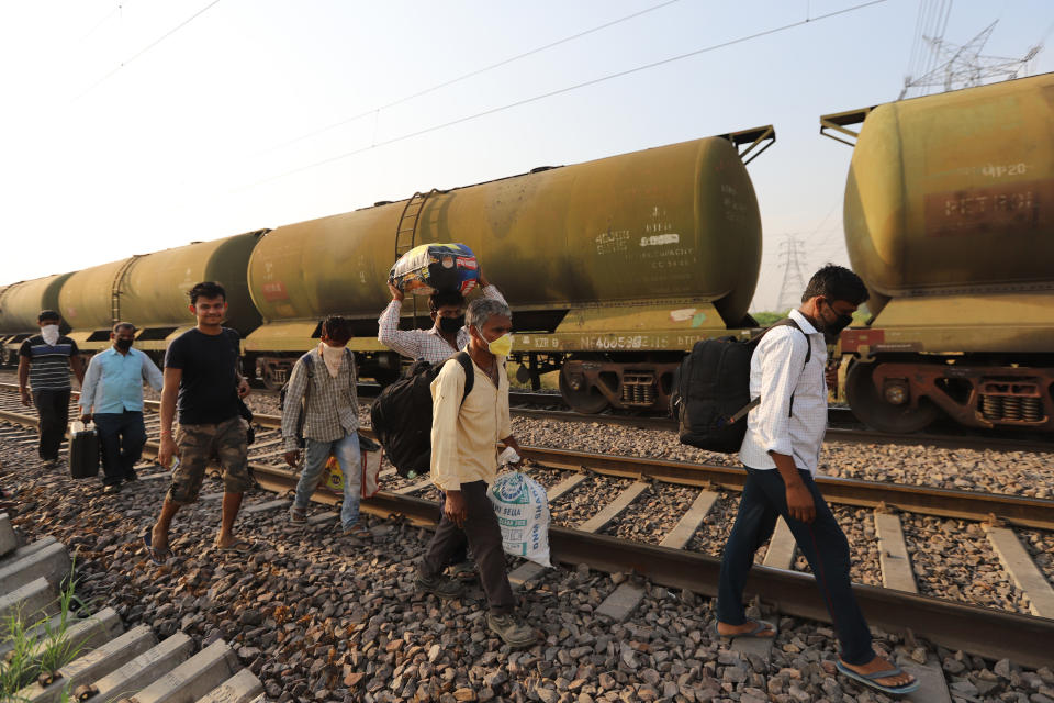 GHAZIABAD, UTTAR PRADESH, INDIA - 2020/05/13: Migrant workers with their belongings walk along a railway track returning to their home, during an extended nationwide lockdown to slow the spread of the coronavirus disease. (Photo by Amarjeet Kumar Singh/SOPA Images/LightRocket via Getty Images)