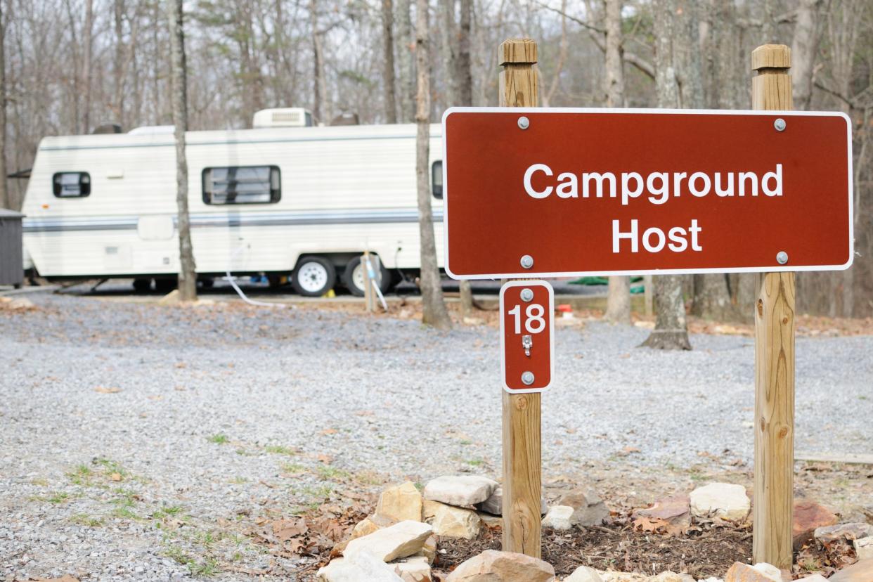 campground host sign with rvs in background 