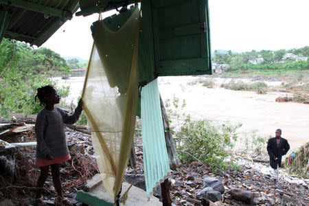 A girl looks through a curtain of her house, which was destroyed by an overflow of the Soco River, in the aftermath of Hurricane Maria in El Seibo, Dominican Republic, September 22, 2017. REUTERS/Ricardo Rojas