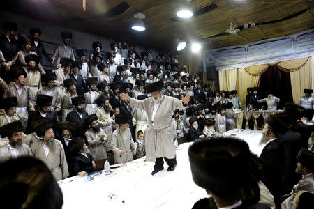 An Ultra-Orthodox Jewish man dances on the table during the celebrations of Simchat Torah in a synagogue at the Mea Shearim neighbourhood of Jerusalem October 1 , 2018. REUTERS/Ronen Zvulun