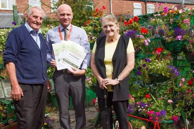 Julie’s mum and stepdad being presented with their certificates and shopping vouchers for garden centres in 2013