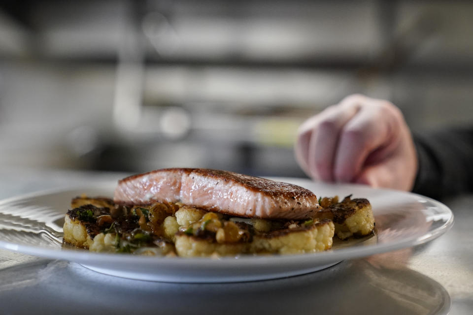 FILE - A farm-raised salmon dish at Scoma's sits before being served to a customer in San Francisco, March 20, 2023. A federal regulatory group has voted to officially close king salmon fishing season along much of the West Coast after near-record low numbers of the fish, also known as Chinook, returned to California's rivers in 2022. (AP Photo/Godofredo A. Vásquez, File)