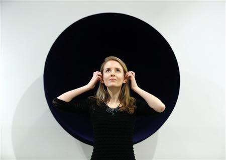 A Christie's employee poses with Anish Kapoor's artwork "Void" at Christie's MAyfair gallery in London February 5, 2014. REUTERS/Luke MacGregor