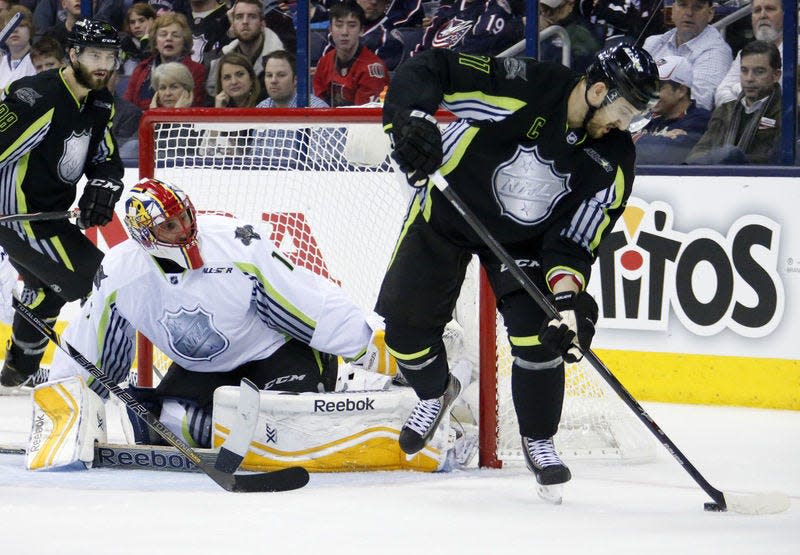 Team Foligno's Nick Foligno (71) of the Columbus Blue Jackets tries a backhand behind the back shot in front of Team Toews' goalie Roberto Luongo of the Florida Panthers during the first period NHL All-Star hockey game in Columbus, Ohio, Sunday, Jan. 25, 2015.(AP Photo/Gene J. Puskar)