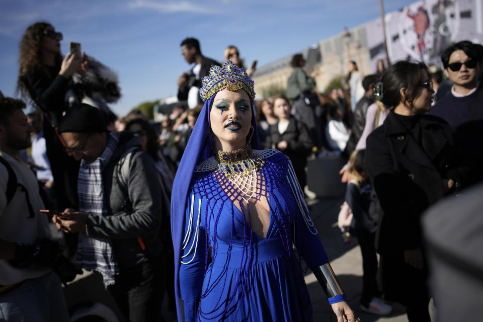 A fashion lover arrives in the courtyard of the Louvre museum during Louis Vuitton ready-to-wear Spring/Summer 2023 fashion collection presented Tuesday, Oct. 4, 2022 in Paris. (AP Photo/Christophe Ena)