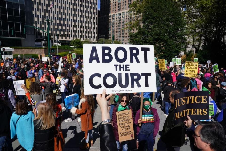 Demonstrators hold signs during a rally to defend abortion access and codify Roe v Wade into law, in Foley Square in New York City on October 8, 2022. (Photo by Bryan R. Smith / AFP) (Photo by BRYAN R. SMITH/AFP via Getty Images)