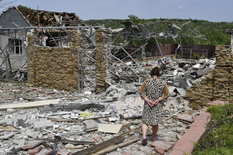 Woman walking past the rubble of a heavily damaged building