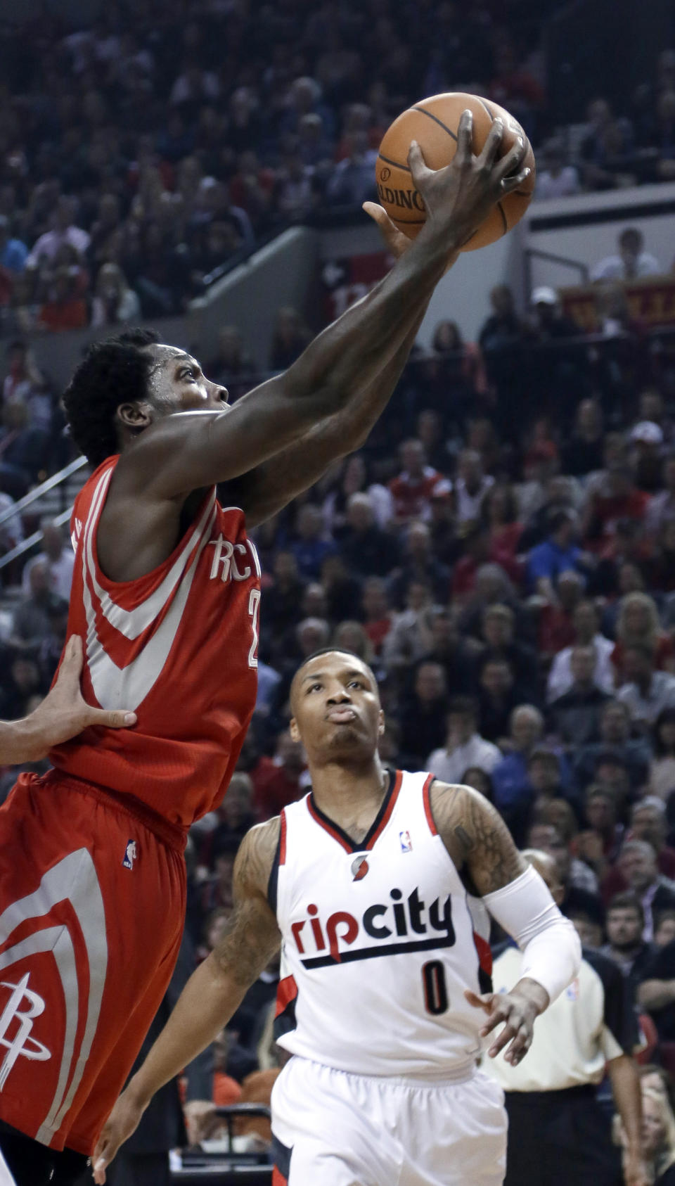 Houston Rockets guard Patrick Beverley, left, goes to the basket asPortland Trail Blazers guard Damian Lillard watches during the first half of Game 3 of an NBA basketball first-round playoff series in Portland, Ore., Friday, April 25, 2014. (AP Photo/Don Ryan)