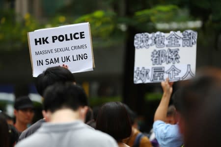 A protester holds up a sign during a protest against what they say is the abuse of pro-democracy protesters by Hong Kong police, at Chater Garden in Central district, Hong Kong