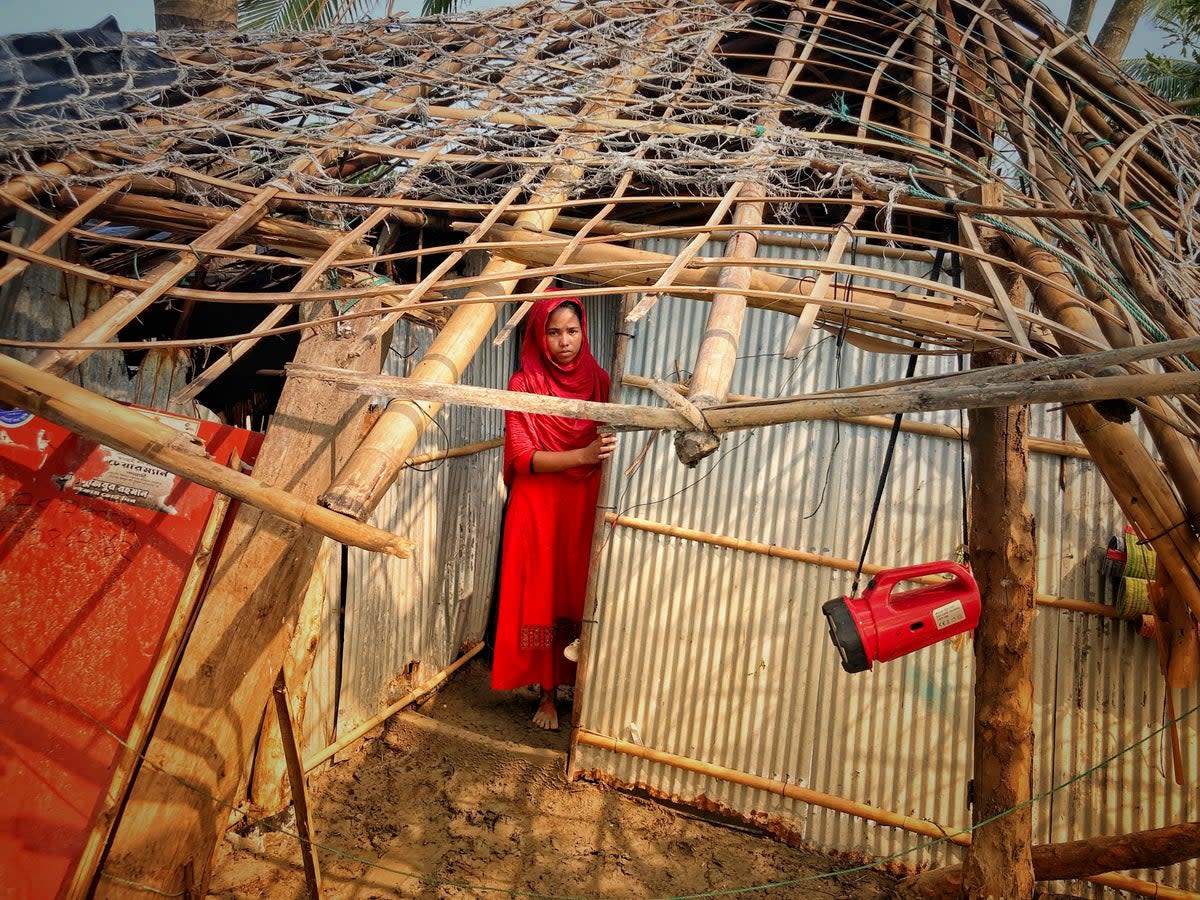 A woman surveys the damage caused to her home by Cyclone Mocha at Saint Martin island in Cox's Bazar, Bangladesh, in May, with the storm causing “widespread devastation” (AP)