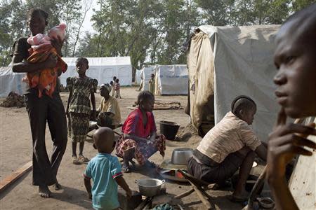 The Kezono family sit in front of their tent in the grounds of Saint Antoine de Padoue cathedral in Bossangoa, Central African Republic, November 25, 2013. REUTERS/Joe Penney