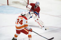 Montreal Canadiens goaltender Jake Allen clears the puck away from Calgary Flames' Brett Ritchie during the third period of an NHL hockey game Friday, April 16, 2021, in Montreal. (Paul Chiasson/The Canadian Press via AP)