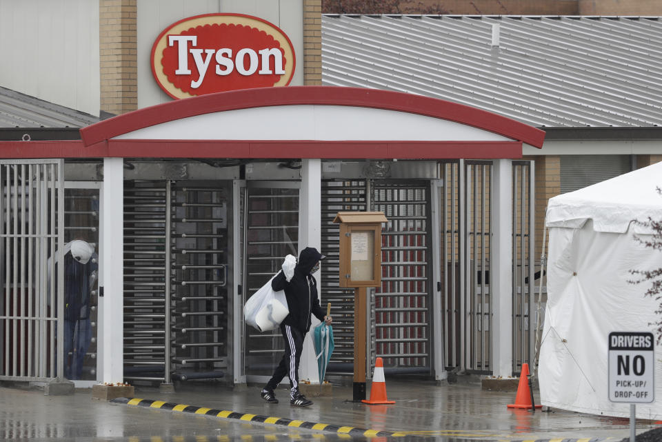 A Tyson Fresh Meats plant employee leaves the plant, Thursday, April 23, 2020, in Logansport, Ind. The plant will temporarily close its meatpacking plant in north-central Indiana after several employees tested positive for COVID-19. (AP Photo/Darron Cummings)