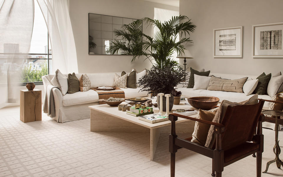 white corner sofa in a white living room with a big potted plant