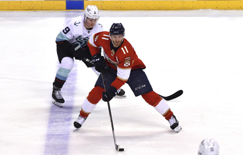 Florida Panthers left wing Jonathan Huberdeau (11) looks to pass as Seattle Kraken center Ryan Donato (9) closes in during the second period of an NHL hockey game Saturday, Nov. 27, 2021, in Sunrise, Fla. (AP Photo/Jim Rassol)