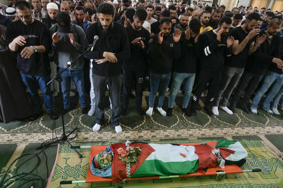 Palestinian men prayer near to the body of Yazan Shtayyeh,17, killed in an Israeli military raid, during his funeral in West Bank village of Salem, Near the Palestinian town of Nablus, Monday, April 15, 2024. (AP Photo/Majdi Mohammed)