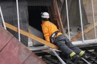 A rescue worker searches a collapsed house caused by powerful earthquake in Suzu, Ishikawa Prefecture Wednesday, Jan. 3, 2024. A series of powerful earthquakes hit western Japan, damaging buildings, vehicles and boats, with officials warning people in some areas on Tuesday to stay away from their homes because of a risk of more strong quakes. (AP Photo/Hiro Komae)