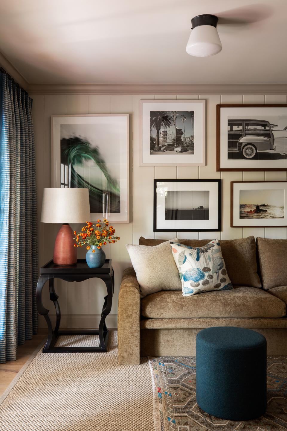 A 12-foot-long sofa in the family room was custom made by Josh Greene. “We used the back of the fabric, as the other side was too pungent,” he says. Beach-themed prints on the walls riff on the house’s West Coast location.