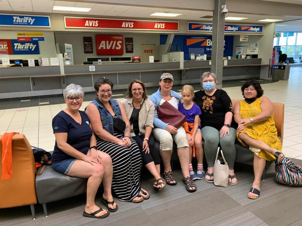 Rosthern's Ukrainian Displaced Families Committee and Ukrainian refugee Oksana Malezhyk, fourth from right, wait for a Ukrainian soldier and expectant mother to arrive at Saskatoon International Airport in 2022. Linda Rudachyk is sitting on the far right end of the group.  (Rosthern's Ukrainian Displaced Families Committee - image credit)
