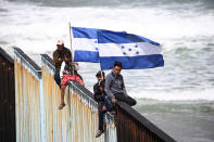 <p>Members of a caravan of migrants from Central America hold Honduran flags while sitting on the border fence between Mexico and the U.S. as a part of a demonstration, prior to preparations for an asylum request in the U.S., in Tijuana, Mexico April 29, 2018. (Photo: Edgard Garrido/Reuters) </p>