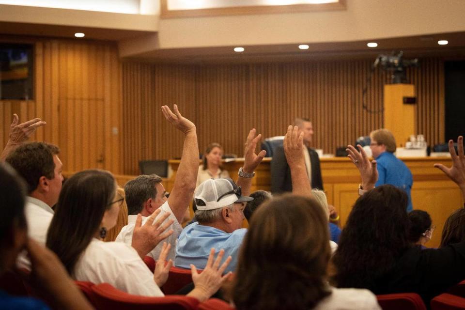 Agriculture and construction leaders raise their hands in opposition to the Miami-Dade heat standard for outdoor workers during a Miami-Dade county commission Community Health Committee meeting on Monday, Sept. 11, 2023, at Government Center in Miami.