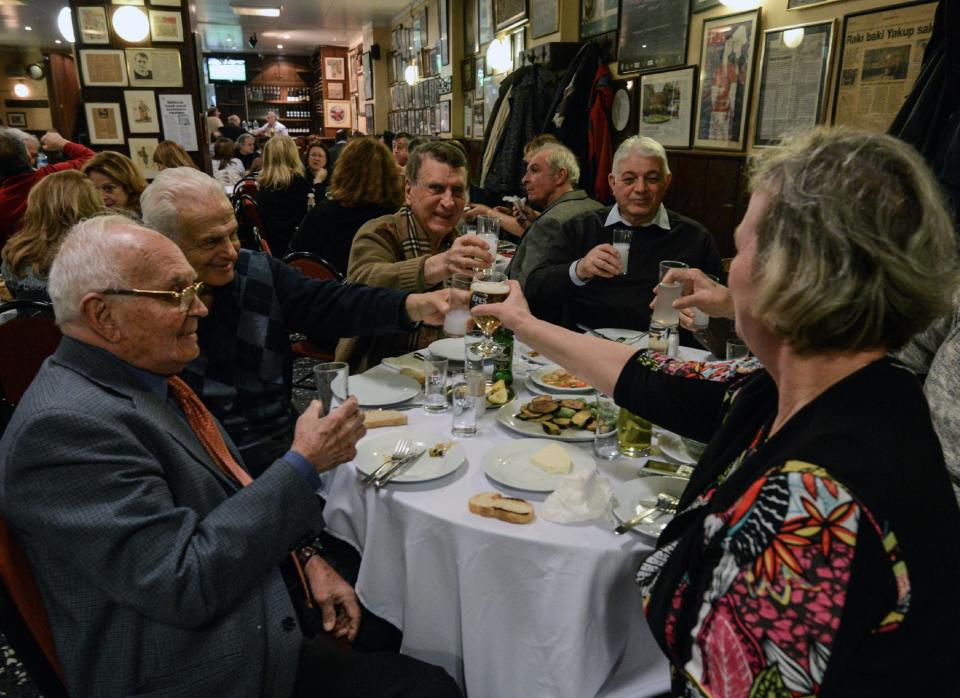 FILE - In this March 16, 2013 file photo, people toast with beer and raki, a traditional Turkish aniseed-based alcoholic drink, at an Istanbul restaurant, Turkey. A look at legislation passed in Turkey's parliament early Friday May 24 2013 that would ban all alcohol advertising and tighten restrictions on the sale of such beverages, and how such a law could affect tourists and liquor companies in the mainly Muslim but secular country.(AP Photo/File)