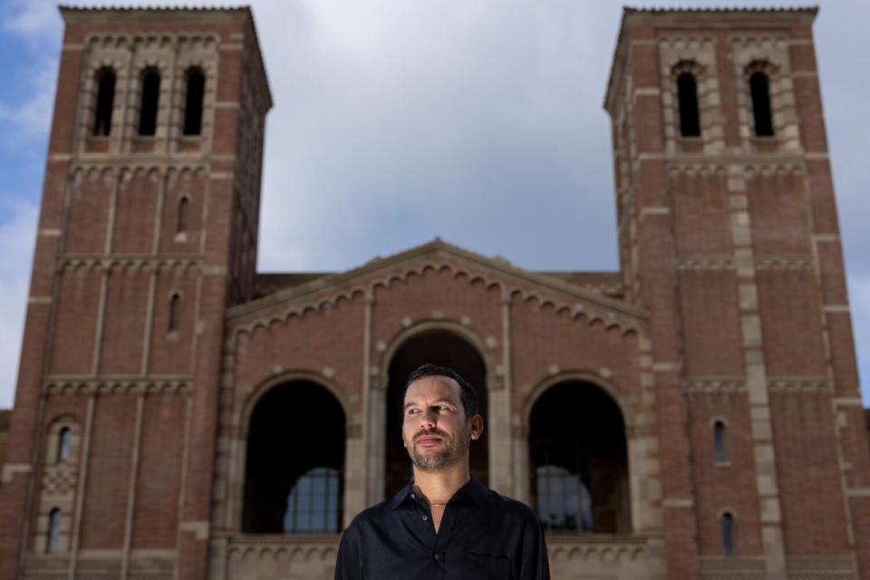 An author in a black shirt stands in front of ornate Royce Hall at UCLA, where he teaches.