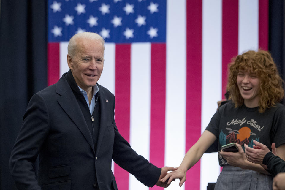 Democratic presidential candidate former Vice President Joe Biden shakes hands with a member of the audience as he arrives at a campaign stop at the South Slope Community Center, Saturday, Feb. 1, 2020, in North Liberty, Iowa. (AP Photo/Andrew Harnik)