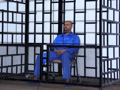 FILE PHOTO: Saif al-Islam Gaddafi, son of late Libyan leader Muammar Gaddafi, attends a hearing behind bars in a courtroom in Zintan May 25, 2014. REUTERS/Stringer/File Photo