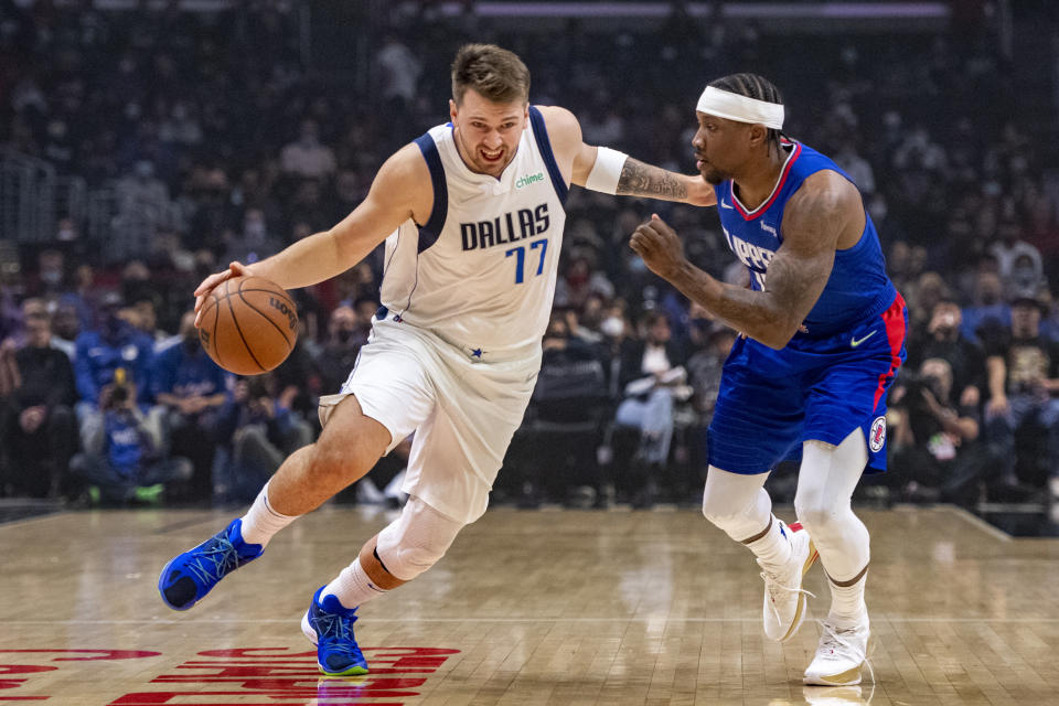 Dallas Mavericks guard Luka Doncic (77) gets past Los Angeles Clippers guard Eric Bledsoe (12) during the first half of an NBA basketball game Tuesday, Nov. 23, 2021, in Los Angeles. (AP Photo/John McCoy)