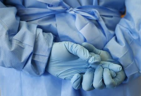 The gloved hands of an army nurse are seen during a demonstration of an isolation chamber for the treatment of infectious disease patients, at the Germany army medical centre, Bundeswehr Clinc, in Koblenz October 16, 2014. REUTERS/Ralph Orlowski