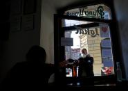 A waitress passes a plastic bottle of beer to a customer in Prague