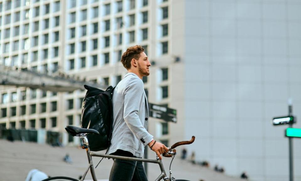 Shot of a young businessman traveling through the city with his bicycle.