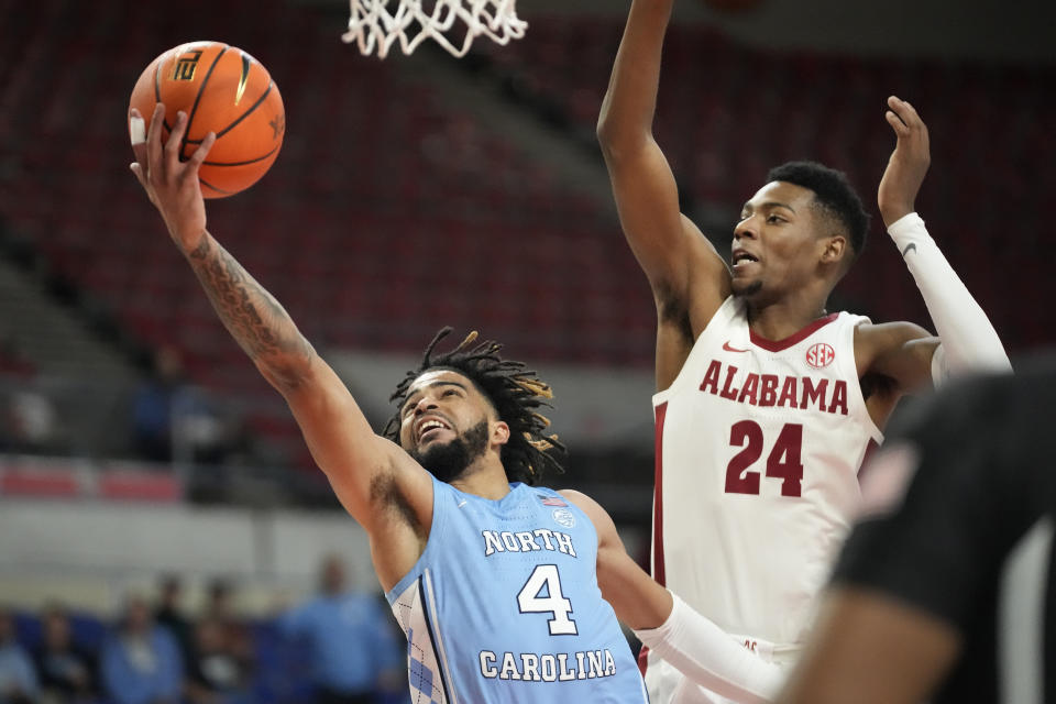 North Carolina guard R.J. Davis (4) goes to the basket as Alabama forward Brandon Miller (24) defends during the first half of an NCAA college basketball game in the Phil Knight Invitational on Sunday, Nov. 27, 2022, in Portland, Ore. (AP Photo/Rick Bowmer)