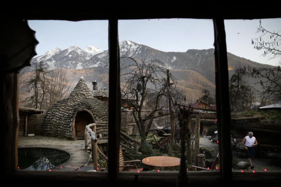 Bathhouse master Ivan Tkach, right, walks through the outdoor sauna area at the British Banya bathhouse, Saturday, Feb. 15, 2014, in Krasnaya Polyana, Russia. "The most important thing about the banya is to have a good spirit in the body," Tkach says. (AP Photo/Jae C. Hong)