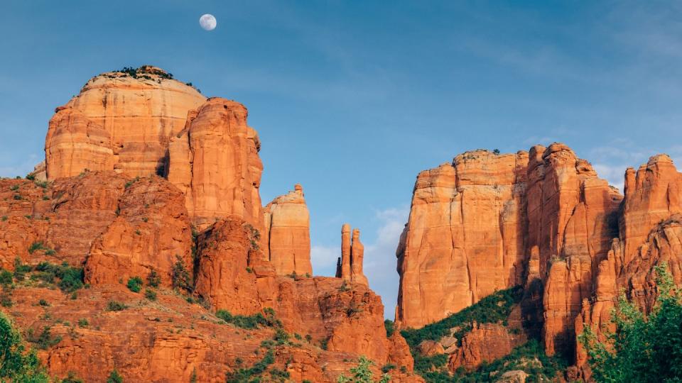 a full moon rises above cathedral rock in sedona