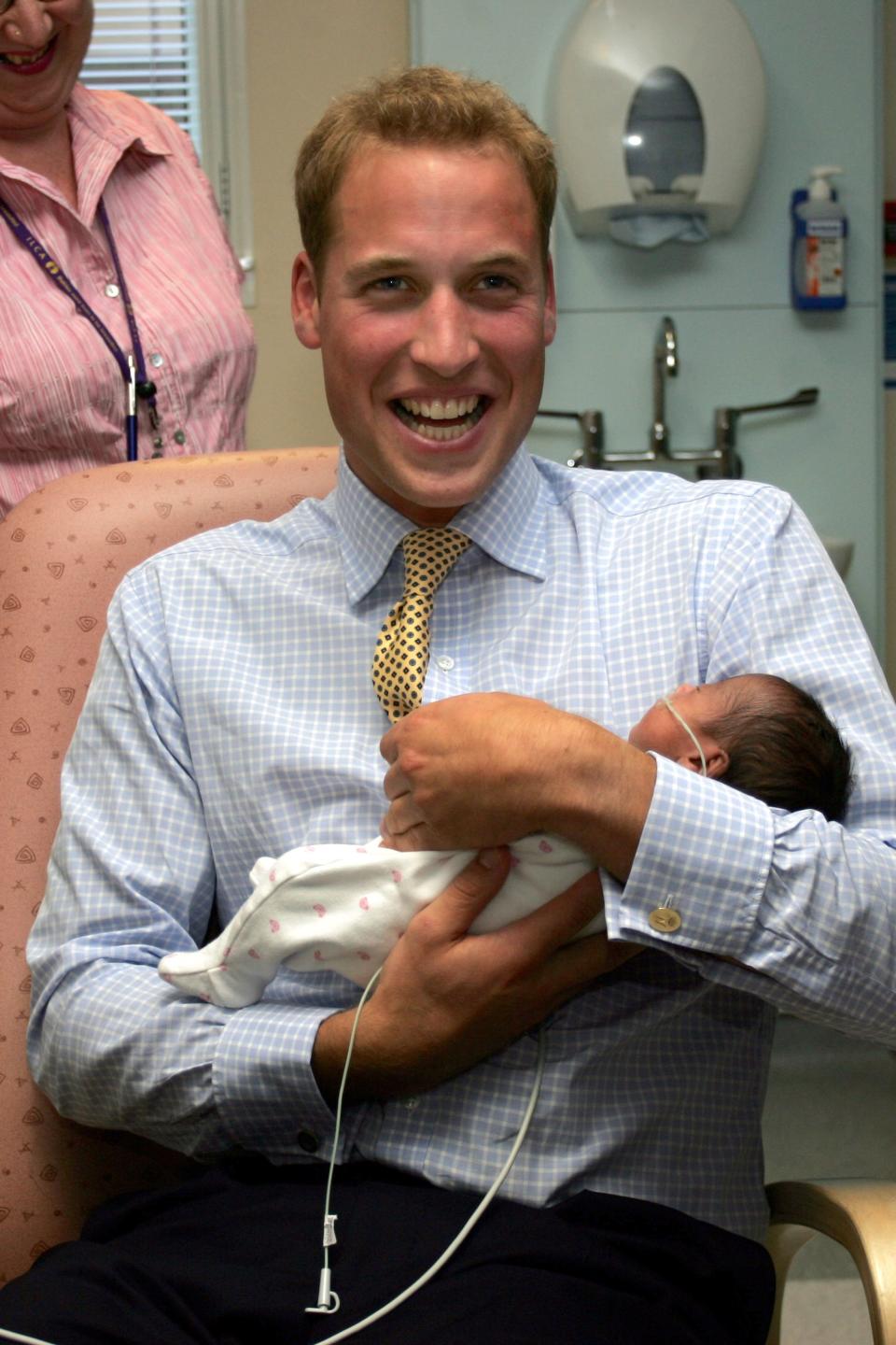 FILE - In this Wednesday Sept. 20, 2006 file photo Britain's Prince William holds baby Sina Nuru in the new Winnicott Baby Unit at the St Mary's Hospital, in London. It was announced on Monday, July 22, 2013, in London that Kate, Duchess of Cambridge and her husband Prince William, the Duke of Cambridge, gave birth to a boy weighting 8lbs 6 oz. (AP Photo/Tom Hevezi, File)