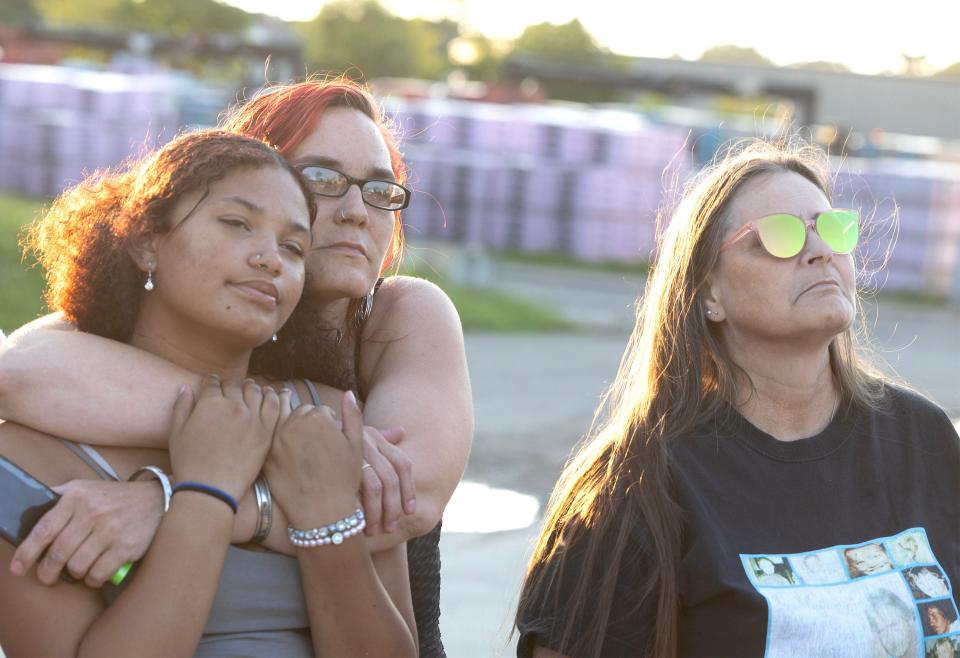 Cassidy Broad hugs her daughter, MyKeigh Broad, as they watch balloons fly away during an event marking the 20th anniversary of the unsolved murder of Michael Broad, who was their father and grandfather, respectively.