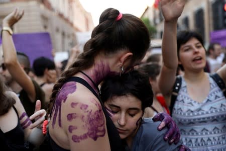 FILE PHOTO: Protesters embrace during a demonstration against the release on bail of five men known as the "Wolf Pack" cleared of gang rape of a teenager and convicted of a lesser crime of sexual abuse in Madrid
